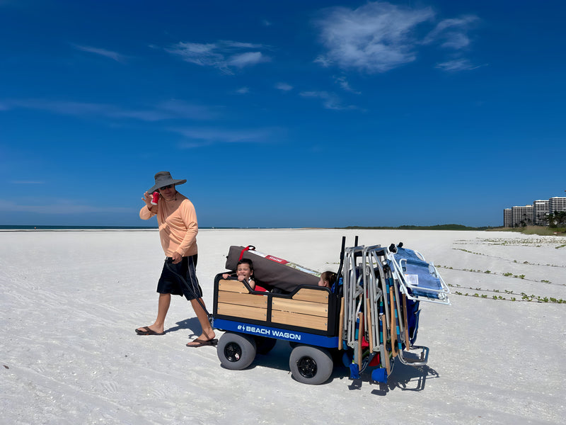 Family enjoying the beach with an e-Beach Wagon loaded with gear